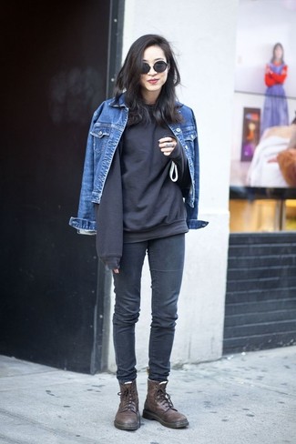 blaue Jeansjacke, schwarzes Sweatshirt, dunkelgraue enge Jeans, dunkelbraune flache Stiefel mit einer Schnürung aus Leder für Damen