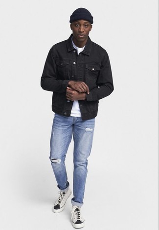 schwarze Jeansjacke, weißes T-Shirt mit einem Rundhalsausschnitt, hellblaue Jeans mit Destroyed-Effekten, weiße und schwarze hohe Sneakers aus Segeltuch für Herren