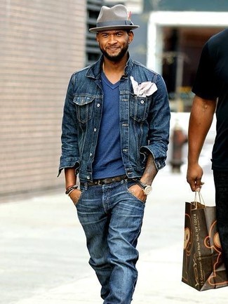 Usher trägt dunkelblaue Jeansjacke, blaues T-Shirt mit einem V-Ausschnitt, dunkelblaue Jeans, grauer Wollhut