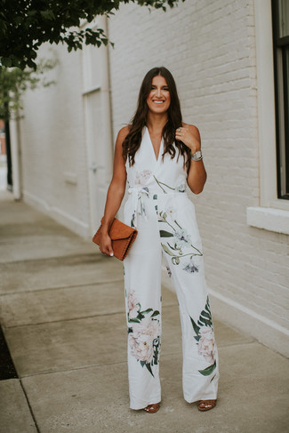 Damen Outfits 2023: Wahlen Sie einen weißen Jumpsuit mit Blumenmuster für einen entspannten Look. Braune Leder Sandaletten sind eine perfekte Wahl, um dieses Outfit zu vervollständigen.