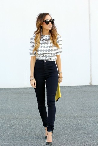 Smart-Casual Outfits Damen 2024: Eine graue bedruckte Kurzarmbluse und schwarze enge Jeans sind die Fashion-Vorlieben der modernen Frau von heute. Schwarze Leder Pumps sind eine großartige Wahl, um dieses Outfit zu vervollständigen.
