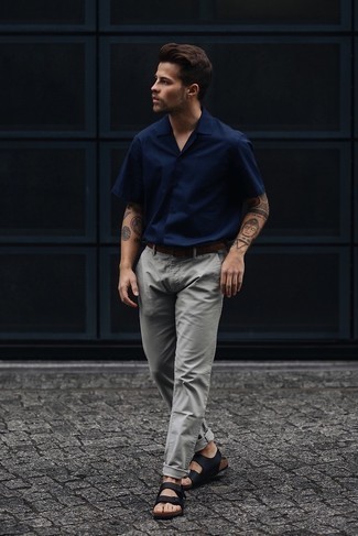 20 Jährige: Dunkelblaues Kurzarmhemd kombinieren – 42 Lässige Sommer Herren Outfits: Kombinieren Sie ein dunkelblaues Kurzarmhemd mit einer grauen Chinohose für ein großartiges Wochenend-Outfit. Fühlen Sie sich mutig? Entscheiden Sie sich für schwarzen Ledersandalen. Das ist eindeutig ein perfekt passender Look für Sommertage!