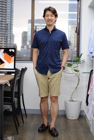 40 Jährige: Beige Shorts kombinieren – 18 Herren Outfits: Kombinieren Sie ein dunkelblaues Kurzarmhemd mit beige Shorts für ein bequemes Outfit, das außerdem gut zusammen passt. Entscheiden Sie sich für dunkelbraunen Leder Slipper, um Ihr Modebewusstsein zu zeigen.