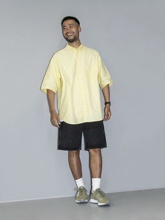 Herren Outfits 2022: Kombinieren Sie ein gelbes Kurzarmhemd mit dunkelgrauen Jeansshorts, um mühelos alles zu meistern, was auch immer der Tag bringen mag. Fühlen Sie sich mutig? Ergänzen Sie Ihr Outfit mit olivgrünen Sportschuhen.