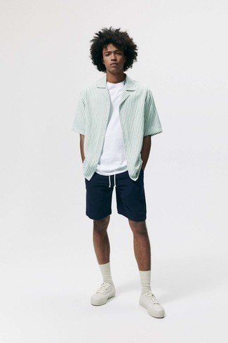 Teenager: Kurzarmhemd kombinieren – 114 Casual Herren Outfits: Kombinieren Sie ein Kurzarmhemd mit dunkelblauen Shorts, um einen lockeren, aber dennoch stylischen Look zu erhalten. Weiße Segeltuch niedrige Sneakers sind eine perfekte Wahl, um dieses Outfit zu vervollständigen.