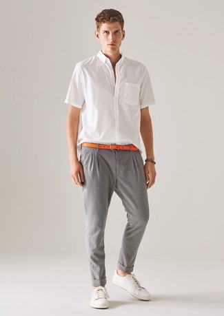 weißes Kurzarmhemd, graue Chinohose, weiße Leder niedrige Sneakers, orange Ledergürtel für Herren