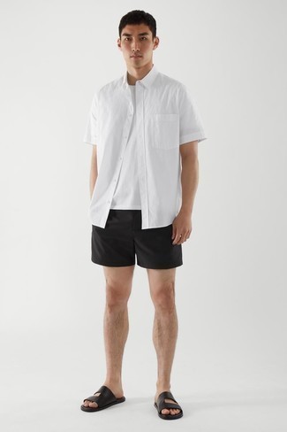 Wie Kurzarmhemd mit Shorts zu kombinieren – 180 Lässige Herren Outfits: Kombinieren Sie ein Kurzarmhemd mit Shorts für ein bequemes Outfit, das außerdem gut zusammen passt. Schwarze Ledersandalen liefern einen wunderschönen Kontrast zu dem Rest des Looks.