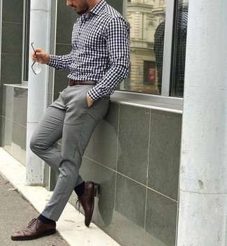 Rotbraune Leder Oxford Schuhe kombinieren – 500+ Herren Outfits: Die Paarung aus einem weißen und schwarzen Langarmhemd mit Vichy-Muster und einer grauen Chinohose ist eine komfortable Wahl, um Besorgungen in der Stadt zu erledigen. Fügen Sie rotbraunen Leder Oxford Schuhe für ein unmittelbares Style-Upgrade zu Ihrem Look hinzu.