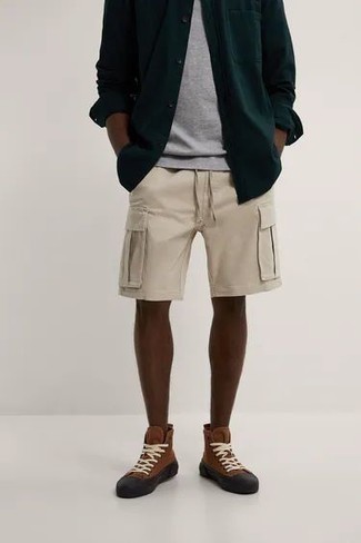dunkelgrünes Langarmhemd, graues T-Shirt mit einem Rundhalsausschnitt, hellbeige Shorts, braune hohe Sneakers aus Segeltuch für Herren