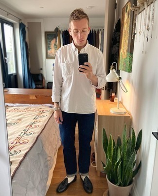 Smart-Casual Sommer Outfits Herren 2024: Kombinieren Sie ein weißes vertikal gestreiftes Langarmhemd mit dunkelblauen Jeans für einen bequemen Alltags-Look. Fühlen Sie sich ideenreich? Vervollständigen Sie Ihr Outfit mit schwarzen Leder Slippern. Der Look ist mega für den Sommer.