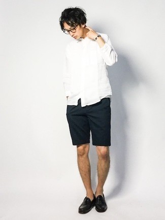 Dunkelblaue Shorts kombinieren – 99 Smart-Casual Sommer Herren Outfits: Kombinieren Sie ein weißes Langarmhemd mit dunkelblauen Shorts, um einen lockeren, aber dennoch stylischen Look zu erhalten. Machen Sie Ihr Outfit mit schwarzen Leder Slippern eleganter. Dieses Outfit ist hervorragend für den Sommer geeignet.