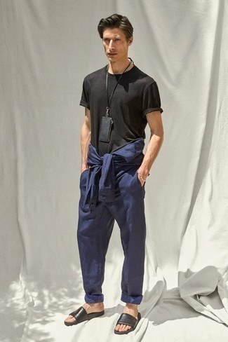 Sommer Outfits Herren 2024: Kombinieren Sie ein dunkelblaues Langarmhemd mit einer dunkelblauen Chinohose, um einen lockeren, aber dennoch stylischen Look zu erhalten. Machen Sie diese Aufmachung leger mit schwarzen Ledersandalen. So einfach kann ein stylisches Sommer-Outfit sein.