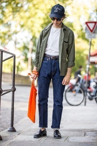 Sommer Outfits Herren 2022: Kombinieren Sie ein olivgrünes Langarmhemd mit dunkelblauen Jeans für einen bequemen Alltags-Look. Setzen Sie bei den Schuhen auf die klassische Variante mit schwarzen Leder Slippern. Dieser Look ist super für den Sommer und gefallen uns sehr gut.