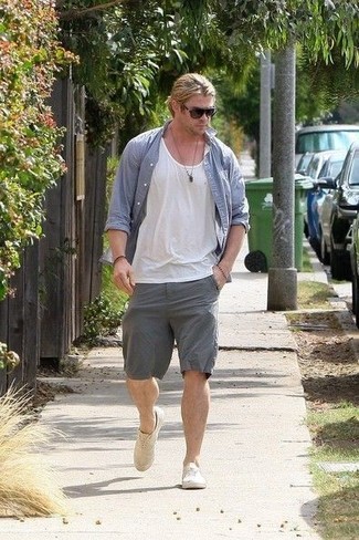 Chris Hemsworth trägt blaues Chambray Langarmhemd, weißes Trägershirt, graue Shorts, hellbeige Segeltuch niedrige Sneakers