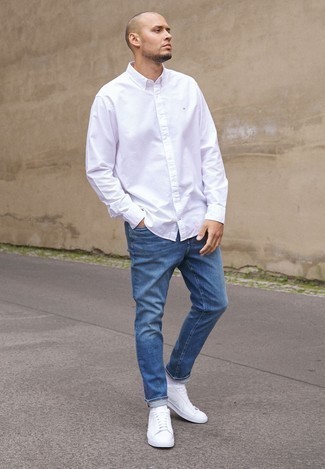 Wie blaue Jeans mit weißen Hemdes zu kombinieren – 500+ Sommer Herren Outfits: Vereinigen Sie ein weißes Hemd mit blauen Jeans für ein großartiges Wochenend-Outfit. Fühlen Sie sich mutig? Wählen Sie weißen Segeltuch niedrige Sneakers. Damit ist ein Look entstanden, der sommertauglich ist.