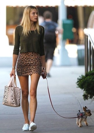 Jessica Hart trägt dunkelgrünes Langarmshirt, brauner Minirock mit Leopardenmuster, weiße niedrige Sneakers, hellbeige Shopper Tasche mit Leopardenmuster