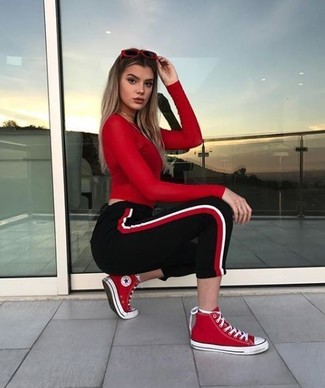 Hohe Sneakers kombinieren – 312 Damen Outfits: Wahlen Sie ein rotes Langarmshirt und eine schwarze vertikal gestreifte Jogginghose, um einen modernen Casual-Look zu kreieren. Hohe Sneakers sind eine perfekte Wahl, um dieses Outfit zu vervollständigen.