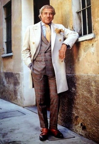 60 Jährige: Braunen Anzug mit Schottenmuster kombinieren – 3 Herren Outfits: Machen Sie sich mit einem braunen Anzug mit Schottenmuster und einem weißen Mantel einen verfeinerten, eleganten Stil zu Nutze. Vervollständigen Sie Ihr Look mit beige Doppelmonks aus Leder.