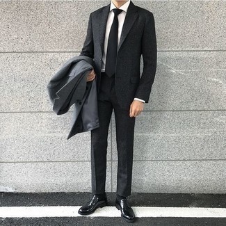 Grauen Mantel kombinieren – 337 Elegante Herren Outfits kalt Wetter: Paaren Sie einen grauen Mantel mit einem dunkelgrauen Wollanzug für eine klassischen und verfeinerte Silhouette. Wenn Sie nicht durch und durch formal auftreten möchten, vervollständigen Sie Ihr Outfit mit schwarzen Leder Derby Schuhen.