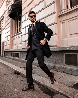 Braune Leder Slipper kombinieren – 126 Elegante Herren Outfits kühl Wetter: Kombinieren Sie einen schwarzen Mantel mit einem schwarzen vertikal gestreiften Anzug, um vor Klasse und Perfektion zu strotzen. Braune Leder Slipper fügen sich nahtlos in einer Vielzahl von Outfits ein.