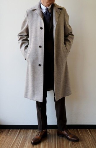 50 Jährige: Braune Leder Oxford Schuhe kombinieren – 14 Elegante Herren Outfits kalt Wetter: Erwägen Sie das Tragen von einem beigen Mantel und einem dunkelbraunen Anzug, um vor Klasse und Perfektion zu strotzen. Vervollständigen Sie Ihr Look mit braunen Leder Oxford Schuhen.