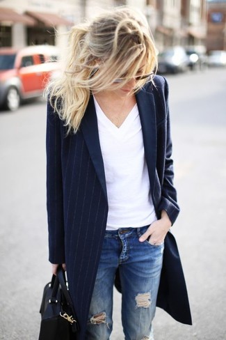 dunkelblauer vertikal gestreifter Mantel, weißes T-Shirt mit einem V-Ausschnitt, blaue Jeans mit Destroyed-Effekten, schwarze Shopper Tasche aus Leder für Damen