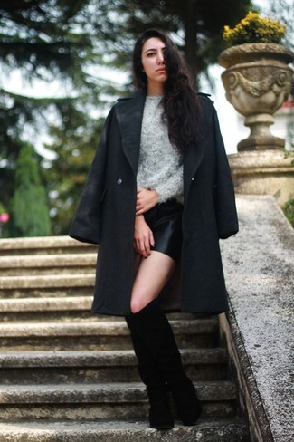 dunkelgrauer Mantel, grauer flauschiger Pullover mit einem Rundhalsausschnitt, schwarze Ledershorts, schwarze kniehohe Stiefel aus Wildleder für Damen