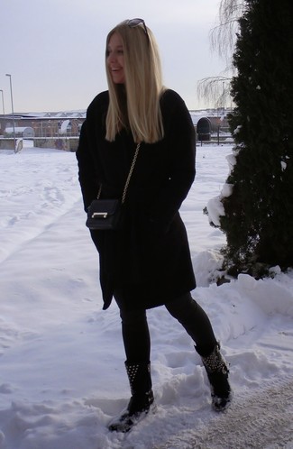 schwarzer Mantel, schwarze enge Jeans, schwarze beschlagene flache Stiefel mit einer Schnürung aus Leder, schwarze Leder Umhängetasche für Damen