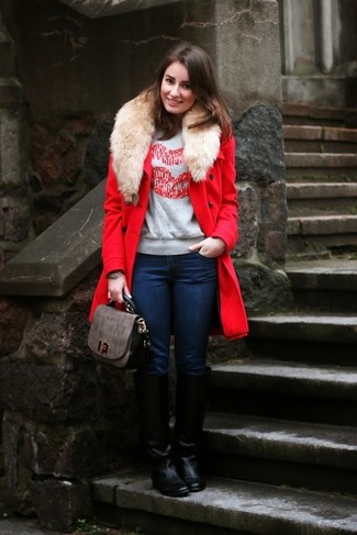 roter Mantel mit einem Pelzkragen, grauer bedruckter Pullover mit einem Rundhalsausschnitt, dunkelblaue enge Jeans, schwarze kniehohe Stiefel aus Leder für Damen