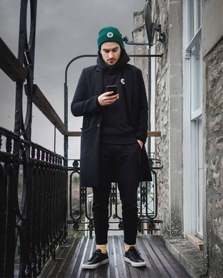 schwarzer Mantel, schwarzer Pullover mit einem Kapuze, schwarze Chinohose, schwarze Leder niedrige Sneakers für Herren