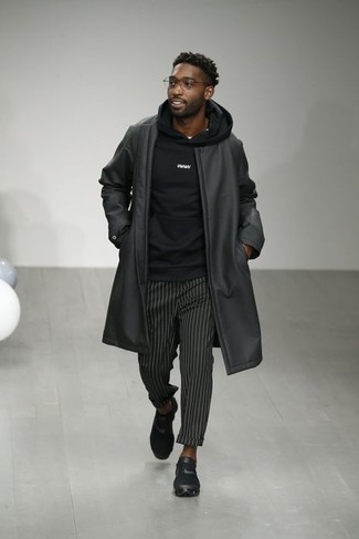 schwarzer Ledermantel, schwarzer Pullover mit einem Kapuze, schwarze vertikal gestreifte Chinohose, schwarze Sportschuhe für Herren