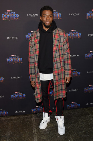 Chadwick Boseman trägt roter Mantel mit Schottenmuster, schwarzer Pullover mit einem Kapuze, weißes T-Shirt mit einem Rundhalsausschnitt, rote und schwarze vertikal gestreifte Jogginghose