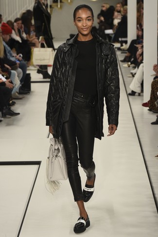 schwarzer gesteppter Ledermantel, schwarzer Pullover mit einem Rundhalsausschnitt, schwarze Leder enge Jeans, schwarze und weiße Leder Slipper für Damen