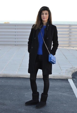 schwarzer Mantel, blauer Pullover mit einem Rundhalsausschnitt, schwarze enge Jeans, schwarze Ugg Stiefel für Damen