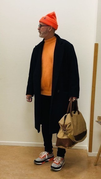 schwarzer Mantel, orange Pullover mit einem Rundhalsausschnitt, schwarze Jeans, graue Sportschuhe für Herren