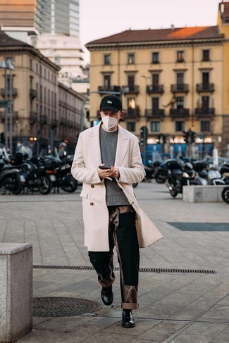 Smart-Casual kalt Wetter Outfits Herren 2024: Die Kombination aus einem beigen Mantel und schwarzen Jeans mit Flicken eignet sich hervorragend zum Ausgehen oder für modisch-lässige Anlässe. Fühlen Sie sich ideenreich? Ergänzen Sie Ihr Outfit mit schwarzen Leder Slippern.