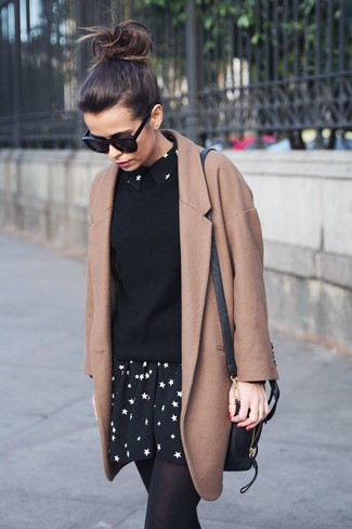 hellbeige Mantel, schwarzer Pullover mit einem Rundhalsausschnitt, schwarzes und weißes Skaterkleid mit Sternenmuster, schwarze Leder Umhängetasche für Damen