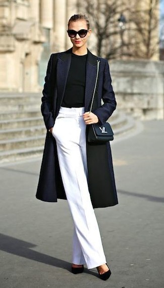 dunkelblauer Mantel, schwarzer Pullover mit einem Rundhalsausschnitt, weiße weite Hose, schwarze Wildleder Pumps für Damen