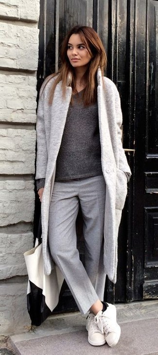 grauer Mantel, dunkelgrauer Pullover mit einem V-Ausschnitt, graue Wollanzughose, weiße Leder niedrige Sneakers für Damen