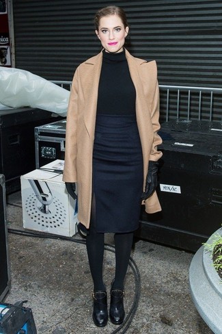 Allison Williams trägt beige Mantel, schwarzer Rollkragenpullover, dunkelblauer Bleistiftrock, schwarze Leder Stiefeletten mit Ausschnitten