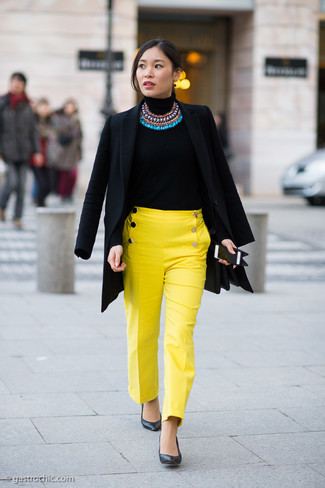 Gelbe enge Hose kombinieren – 27 Damen Outfits: Vereinigen Sie einen schwarzen Mantel mit einer gelben enger Hose, um eine gemütliche und gleichzeitig klassische Stimmung zu erschaffen. Schwarze Leder Pumps fügen sich nahtlos in einer Vielzahl von Outfits ein.