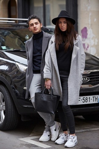 grauer Mantel, schwarzer Rollkragenpullover, schwarze enge Hose aus Leder, weiße niedrige Sneakers für Damen