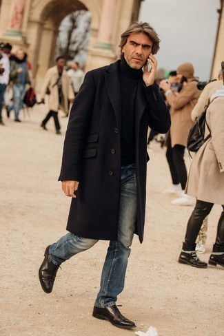 40 Jährige: Smart-Casual warm Wetter Outfits Herren 2024: Kombinieren Sie einen schwarzen Mantel mit blauen Jeans, um einen modischen Freizeitlook zu kreieren. Ergänzen Sie Ihr Outfit mit schwarzen Leder Brogues, um Ihr Modebewusstsein zu zeigen.