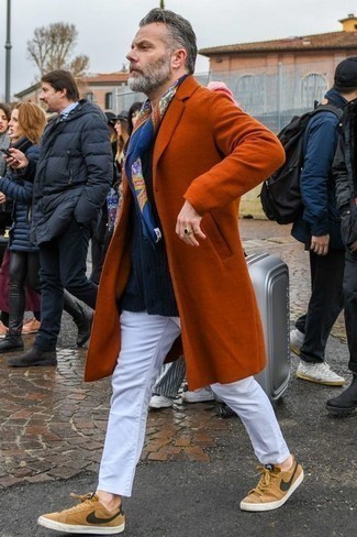 orange Mantel, dunkelblaue Strickjacke mit einem Schalkragen, weiße Chinohose, beige Segeltuch niedrige Sneakers für Herren