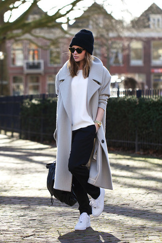 grauer Mantel, weißes T-Shirt mit einem Rundhalsausschnitt, schwarze Jogginghose, weiße Sportschuhe für Damen