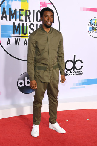 Chadwick Boseman trägt olivgrüne Bomberjacke, olivgrüne Anzughose, weiße Leder niedrige Sneakers