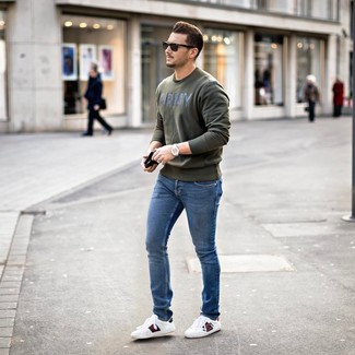 Dunkelgrünes bedrucktes Sweatshirts kombinieren – 20 Herren Outfits: Für ein bequemes Couch-Outfit, entscheiden Sie sich für ein dunkelgrünes bedrucktes Sweatshirts und blauen enge Jeans. Weiße bedruckte Leder niedrige Sneakers sind eine einfache Möglichkeit, Ihren Look aufzuwerten.
