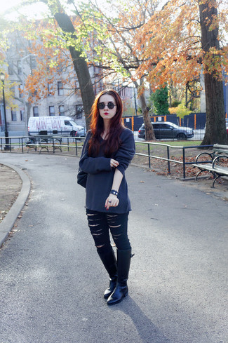 dunkelgrauer Oversize Pullover, schwarze enge Jeans mit Destroyed-Effekten, schwarze kniehohe Stiefel aus Leder, schwarze Leder Umhängetasche für Damen