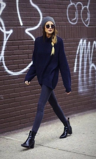 Dunkelblauen Oversize Pullover kombinieren – 30 Damen Outfits: Beherrschen Sie den modischen ultralässigen Alltags-Look in Perfektion einem dunkelblauen Oversize Pullover und dunkelblauen engen Jeans. Schwarze Leder Stiefeletten sind eine ideale Wahl, um dieses Outfit zu vervollständigen.