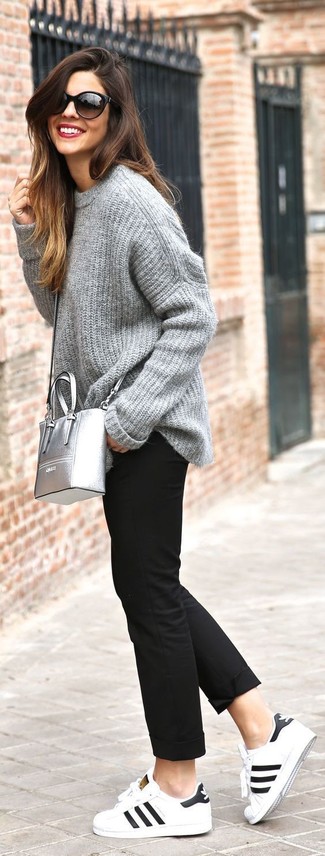 Grauen Strick Oversize Pullover kombinieren – 78 Damen Outfits: Die Kombi aus einem grauen Strick Oversize Pullover und einer schwarzen Chinohose sieht so locker und ansprechend aus. Weiße und schwarze Leder niedrige Sneakers sind eine gute Wahl, um dieses Outfit zu vervollständigen.